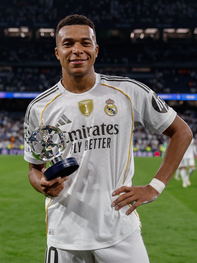 Real Madrid forward, Kylian Mbappe, takes a shot with his Most Valuable Player (MVP) award after his stunning display for the Spanish side