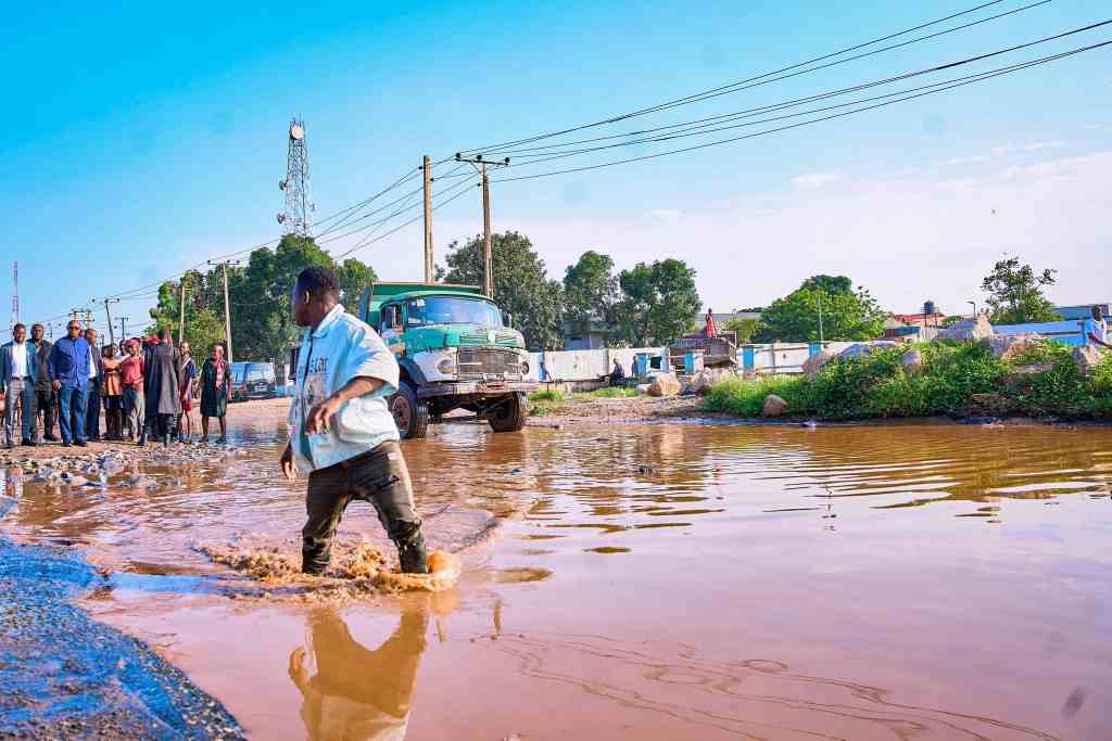 A pedestrian walking on a flooded road