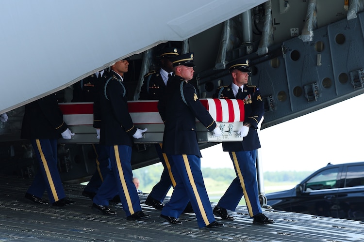 Members of a U.S. Army carry team move the flag-draped transfer case holding the remains of a US soldier of Fayetteville, North Carolina, during a dignified transfer at Dover Air Force Base July 22, 2026 in Dover, Delaware