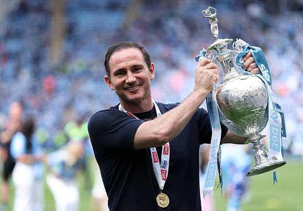 Frank Lampard, Manager of Coventry City, takes a shot with the Championship trophy after winning the League last season