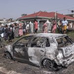 Over 20 k*lled in two mass sh*otings in South Africa 3 Residents stand near a vehicle owned by one of the victims was set ablaze by unknown gunmen at the scene of a mass shooting in the Ziko area of KwaMakhutha, south of Durban on September 23, 2026
